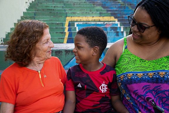 Família inter-racial: três gerações em um momento de afeto, cuidado e descontração.
